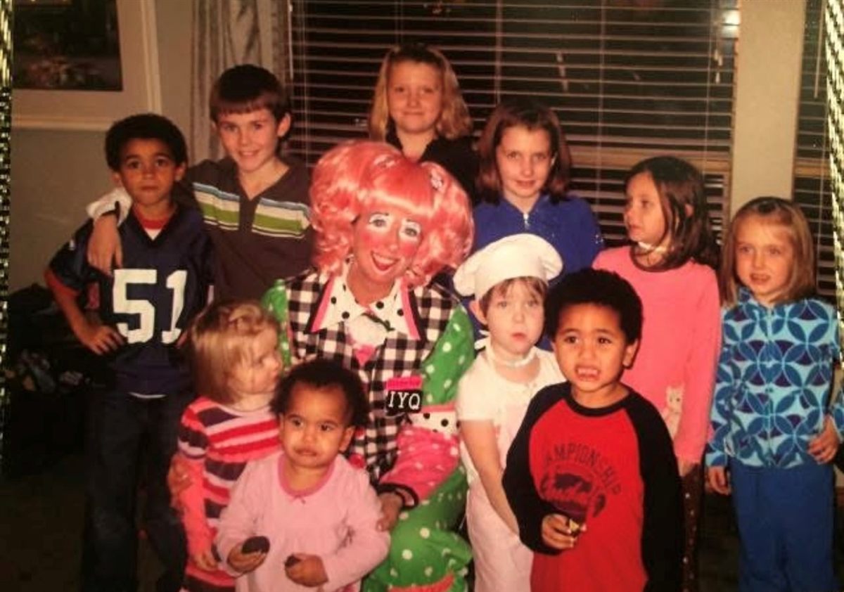 Grandma as a clown surrounded by smiling kids at a party
