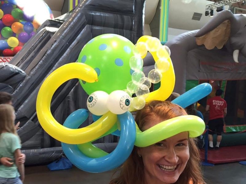 Woman wearing a green and yellow balloon octopus hat