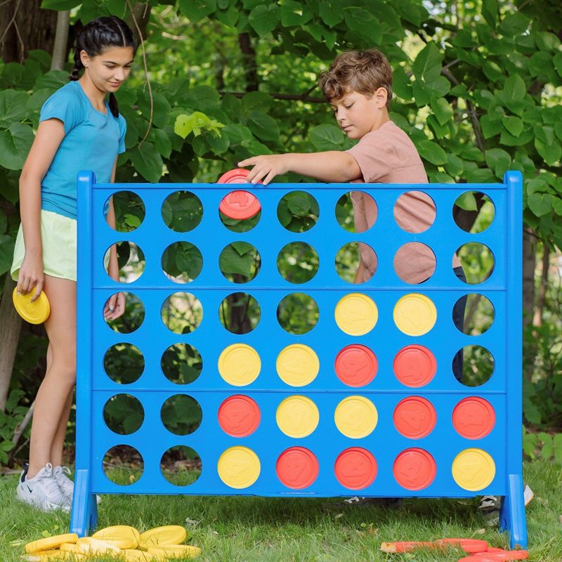 Two kids playing a giant Connect Four carnival game